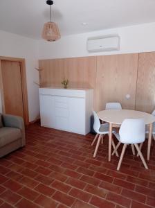 a room with a table and chairs and a kitchen at Casa do Livramento in Luz de Tavira