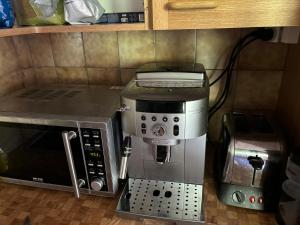 eine Küche mit Kaffeemaschine und Mikrowelle in der Unterkunft AmdenLodge - Gardens Chalet in Amden