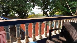 a chair sitting on a railing on a balcony at 12 Monks Hostel in Arambol