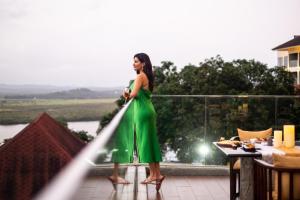 a woman in a green dress standing on a balcony at DoubleTree by Hilton Goa - Panaji in Panaji