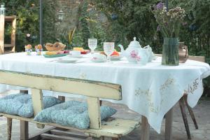 una mesa con mantel blanco y set de té en Merli's Nest, en Ferrara