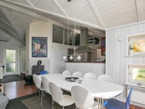 a dining room with a white table and chairs at 11 person holiday home in Str by in Strøby