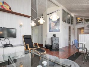 ein Wohnzimmer mit einem TV, einem Tisch und Stühlen in der Unterkunft 11 person holiday home in Str by in Strøby