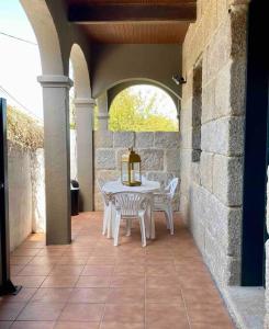 ポンテベドラにあるCasa Alcabre en Vigoの石壁のパティオ(テーブル、椅子付)