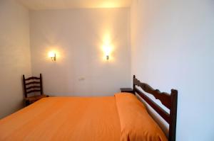 レスカラにあるApartamentos GARBI PARKのベッドルーム1室(オレンジ色のベッド1台、壁に2つの照明付)