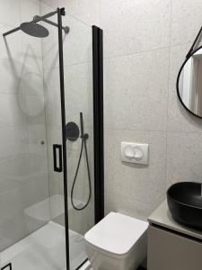 a bathroom with a shower with a toilet and a sink at ROOM 44 in Osijek