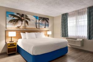 a bedroom with a large bed and a window at Days Inn by Wyndham Miami Airport North in Miami