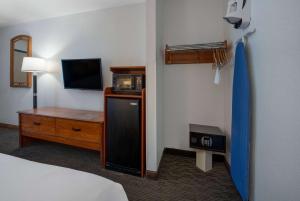 a hotel room with a bed and a tv at Days Inn by Wyndham Encinitas Moonlight Beach in Encinitas