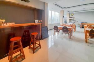 ein Restaurant mit einer Bar mit Stühlen und einem Tisch in der Unterkunft Delvia Bromo Homestay Mitra RedDoorz in Pasuruan