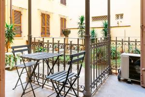 a table and chairs on a balcony with a fence at Venezia Double in Florence