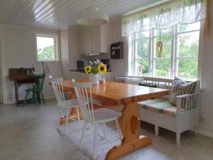 a kitchen and dining room with a wooden table and chairs at Snokebo Gård in Vimmerby