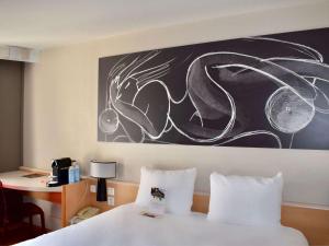 トゥールにあるイビス トゥール サントル ガールのベッドルーム1室(壁に絵画が描かれたベッド1台付)