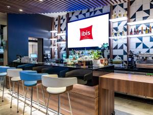 um restaurante com um bar com uma televisão na parede em ibis Lima Larco Miraflores em Lima