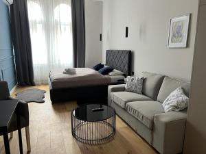 een woonkamer met een bank en een bed bij ROOM 44 in Osijek