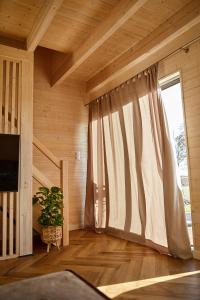 a room with a large window with a curtain at Wood House Trzęsacz in Trzęsacz +38 photos