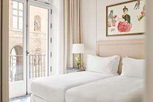 a hotel room with two beds and a window at Hôtel du Louvre, in The Unbound Collection by Hyatt in Paris