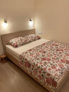 een slaapkamer met een bed met een bloemenbed en kussens bij Apartment Vienna 56 in Wenen