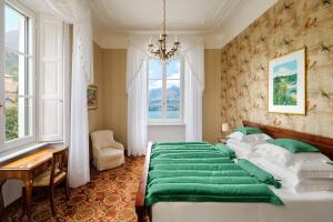 una camera da letto con un grande letto con lenzuola verdi di Grand Hotel Villa Serbelloni - 150 Years of Grandeur a Bellagio