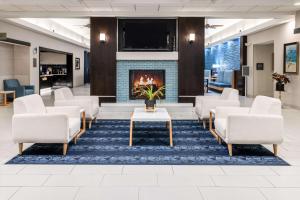 hol z białymi krzesłami i kominkiem w obiekcie Homewood Suites by Hilton Rochester/Greece, NY w mieście Rochester