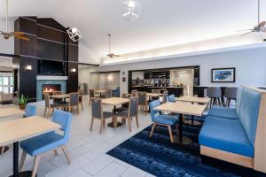 restauracja ze stołami i krzesłami oraz kominkiem w obiekcie Homewood Suites by Hilton Rochester/Greece, NY w mieście Rochester