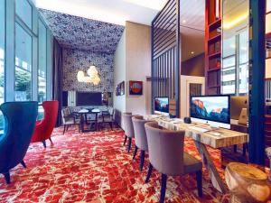 a hotel lobby with a long table and chairs at Mercure Singapore Bugis in Singapore