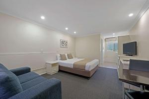 um quarto com uma cama, um sofá e uma televisão em Comfort Inn Glenfield em Toowoomba