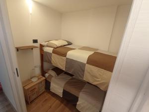 Bilocale Funivie في بيريول تشيرفينيا: غرفة نوم صغيرة بسريرين في غرفة
