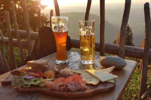 two glasses of beer and a plate of food on a table at Appartement Nr 11, Fewo in Oberstaufen-Steibis in Oberstaufen