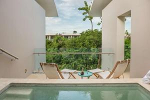a patio with chairs and a swimming pool at Andaz Mayakoba - a concept by Hyatt in Playa del Carmen