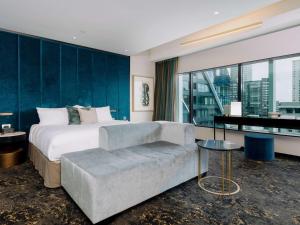 una camera con un grande letto e un divano di SO/ Auckland ad Auckland