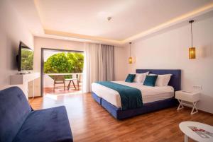 A bed or beds in a room at Ramada Loutraki Poseidon Resort