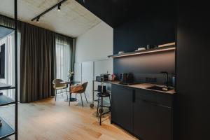 a kitchen with black walls and a table and chairs at HIIVE Oldenburg in Oldenburg