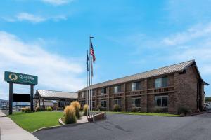 里奇菲尔德Quality Inn Richfield I-70的一座前面有美国国旗的建筑