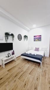 Habitación blanca con cama y TV en OTEIZA, en Madrid