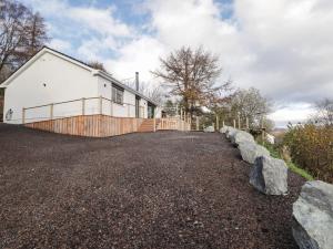 a white house with a fence and a driveway at The Lookout in Saasaig