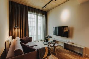 a living room with a couch and a flat screen tv at HIIVE Oldenburg in Oldenburg