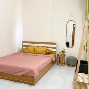 een slaapkamer met een bed en een spiegel bij Mayhome Phan Rang - 2BR City view - 3km to beach in Kinh Dinh