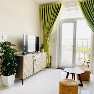 een woonkamer met een televisie en een tafel bij Mayhome Phan Rang - 2BR City view - 3km to beach in Kinh Dinh