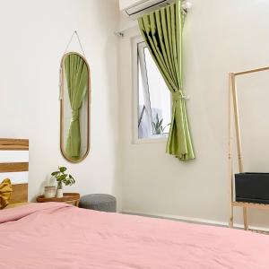 een slaapkamer met een roze bed en een raam bij Mayhome Phan Rang - 2BR City view - 3km to beach in Kinh Dinh +16 foto's