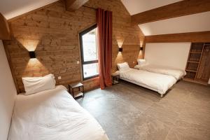 サン・マルタン・ヴェジュビーにあるPure Montagne Resort & Spaの木製の壁のベッドルーム1室(ベッド2台付)
