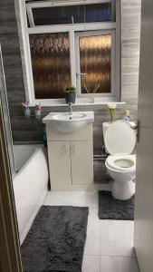 a bathroom with a toilet and a sink and a tub at Divine Room in London