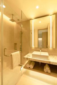 a bathroom with a sink and a shower and a mirror at Hyatt Place Bharuch in Bharuch