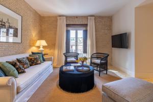 塞维利亚Casa de la Moneda Residences Sevilla的带沙发和桌子的客厅