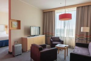 a hotel room with a television and a living room at Cosmos Yaroslav Hotel, a member of Radisson Individuals in Yaroslavl