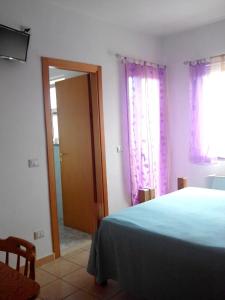 ヴィッラピアーナにあるHotel Celestinaのベッドルーム(青いベッド1台、鏡付)