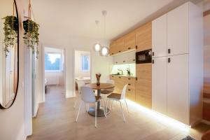 een keuken en eetkamer met een tafel en stoelen bij MF Club 218 Garden Apartments in Siófok