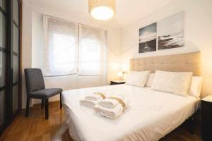 een slaapkamer met een bed met twee handdoeken erop bij San Miguel Playa in Gijón