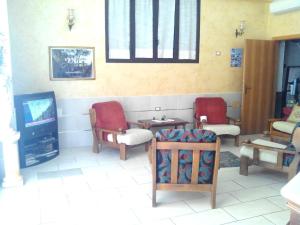 a living room with two chairs and a tv at Hotel Celestina in Villapiana