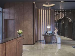 a woman standing at a desk in a lobby at Pullman Singapore Hill Street in Singapore