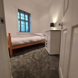 ein Schlafzimmer mit einem Bett, einer Kommode und einem Fenster in der Unterkunft Crossways Cottage Quirky 2 bedroom cottage in Central location in Peebles